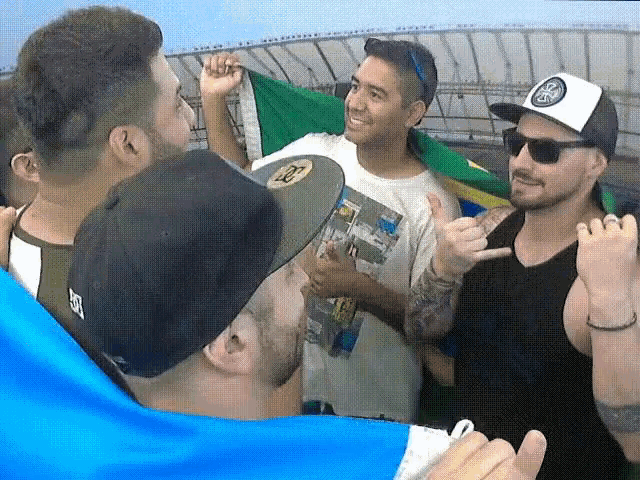 a man wearing a hat with the letter s on it is surrounded by other people