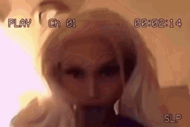 a close up of a woman 's face with a wig on and a video tape .