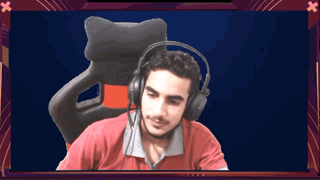 a man wearing headphones and a red shirt sitting in a chair