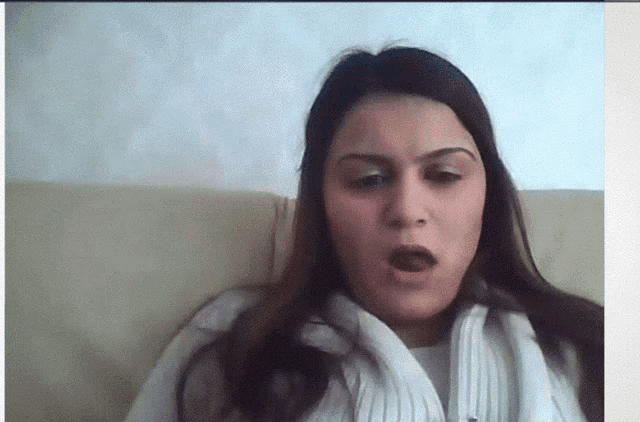 a woman sitting on a couch making a funny face