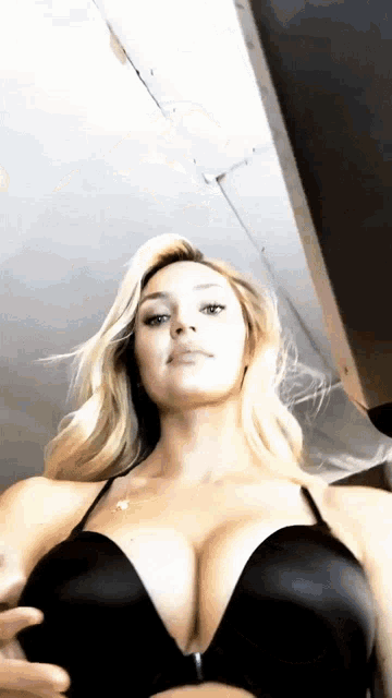 a woman is wearing a black bra with a zipper on the front