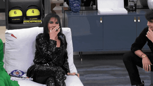 a woman sits on a couch in front of a sign that says " fitexpress "