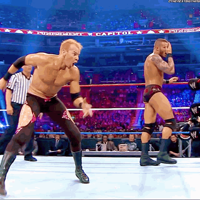 two men in a wrestling ring with the word capitol on the bottom