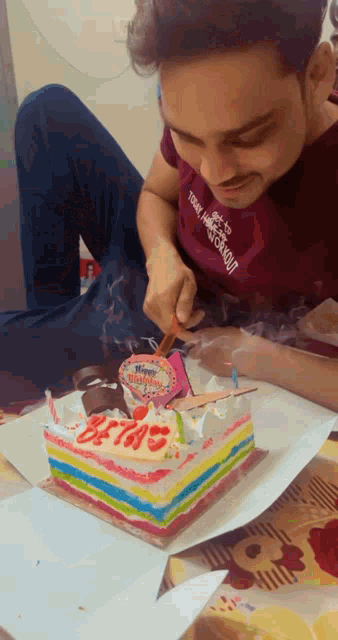a man wearing a shirt that says totally hardcore is lighting a candle on his birthday cake