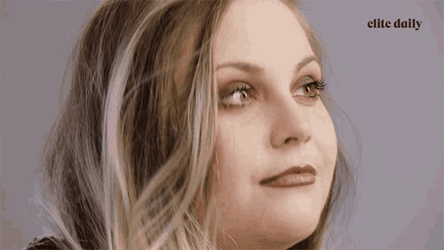 a close up of a woman 's face with the elite daily logo in the corner