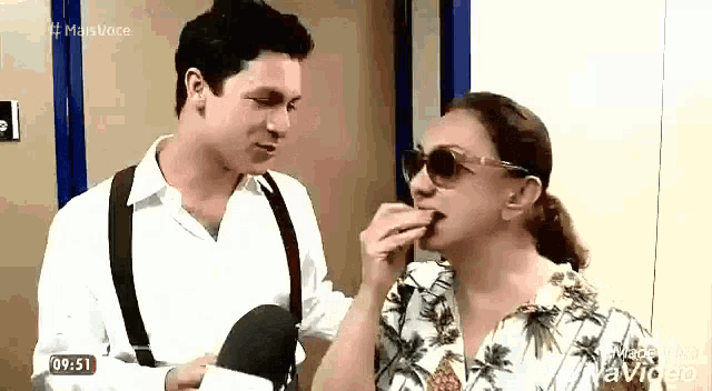 a man and a woman are standing next to each other .