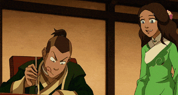 a girl in a green dress stands next to a man in a green robe