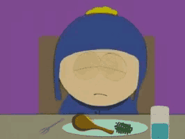 a cartoon character sitting at a table with a plate of food and a glass of water