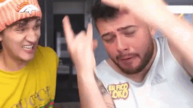 two men are making funny faces and one of them is wearing a yellow shirt that says gucci .