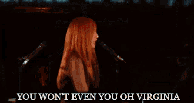a woman singing into a microphone with the words " you won t even you oh virginia " below her