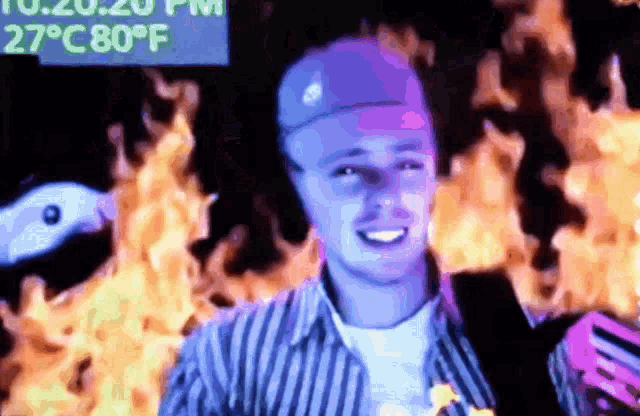 a man in a pizza hut hat is standing in front of a fire