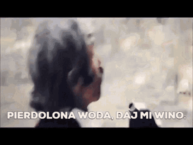a blurry picture of a man with the words pierdolona woda , daj mi wing written in a foreign language .
