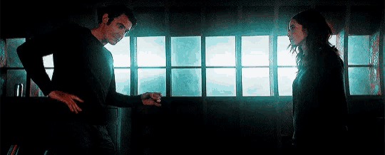 a man and a woman are standing next to each other in a dark room .