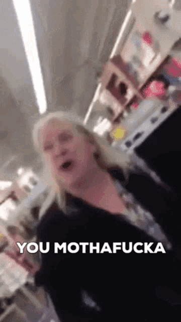 a woman in a black jacket says " you mothafucka " in front of a kitchen