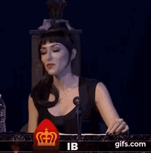 a woman is sitting in front of a microphone and asking how dare .