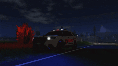 a sheriff 's car is parked on the side of a road at night