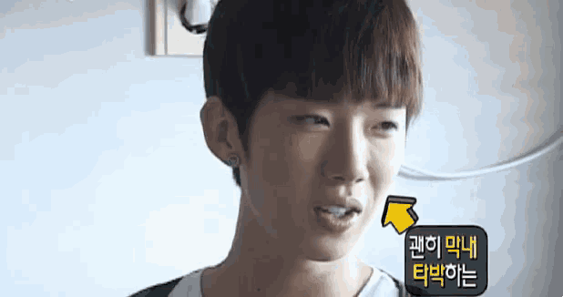 a young man is making a funny face with a yellow arrow pointing at his mouth .