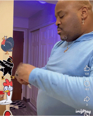 a man in a blue shirt is standing in front of a cartoon chicken and turkey