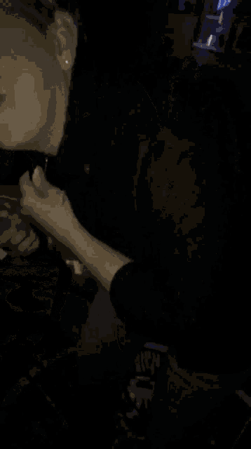 a woman is smiling in a dark room with a bottle of bud light in the background