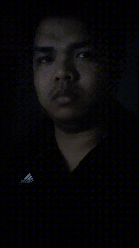 a man wearing a black shirt with the word adidas on it