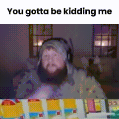 a man with a beard wearing headphones and a hat is sitting at a table with toys .
