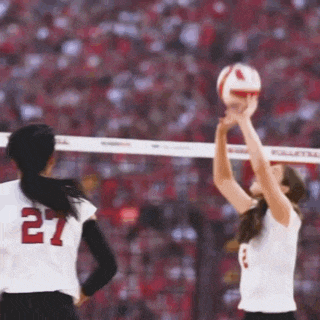 a volleyball player with the number 27 on her jersey is getting ready to serve the ball