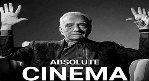 a man sitting in a chair with his hands in the air and the words absolute cinema above him