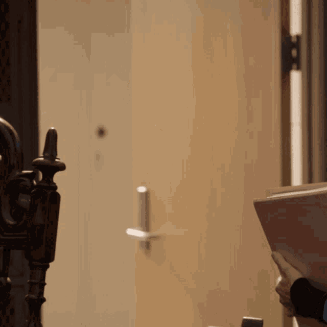 a person holding a pink book standing in front of a door