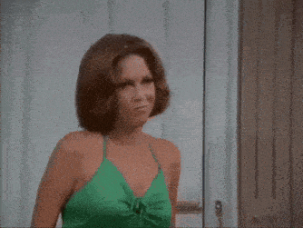 a woman in a green dress is standing in a doorway
