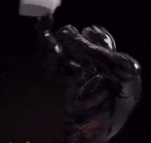 a person is splashing water on their face in a black background .