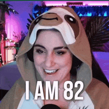 a woman is wearing a sloth costume and says `` i am 82 '' while sitting in front of a microphone .