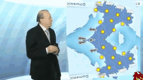 a man in a suit and tie is standing in front of a weather map
