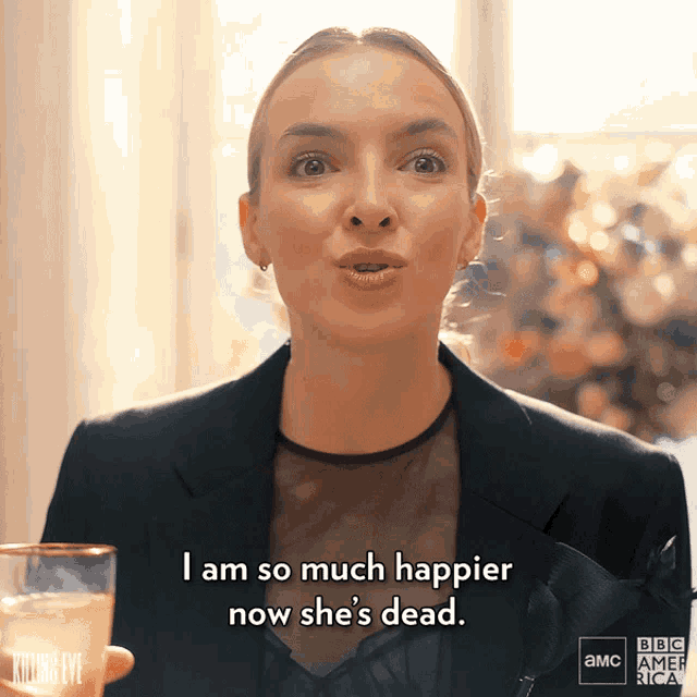 a woman is holding a glass of champagne and saying i am so much happier now she 's dead