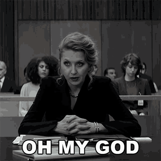 a woman sits at a desk in a courtroom with the words oh my god written below her