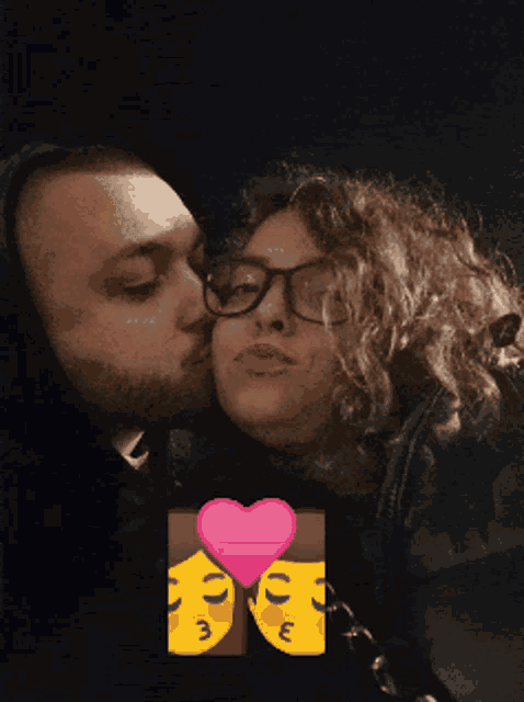 a man is kissing a woman on the cheek in front of a pink heart