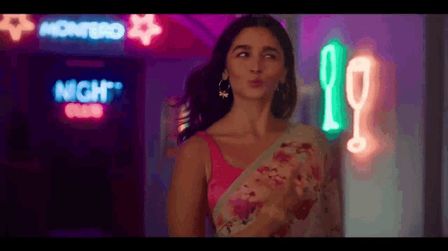 a woman standing in front of a night club sign