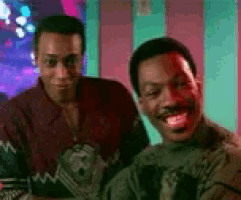 two men are sitting next to each other and one of them has his tongue out