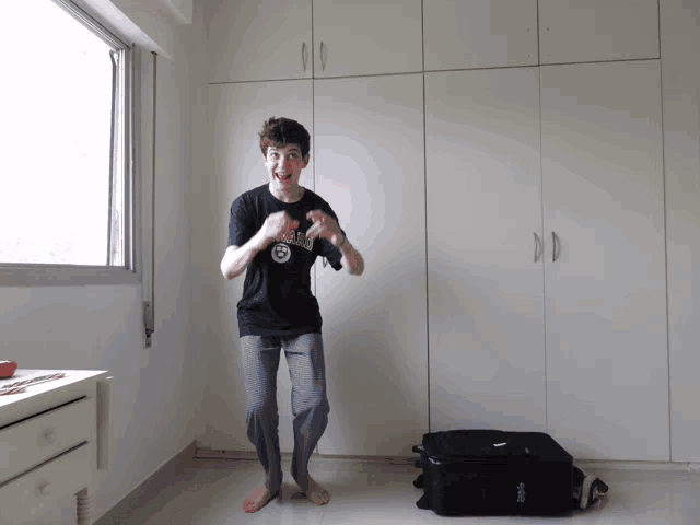 a boy wearing a shirt that says ' miami ' on it is dancing in a room