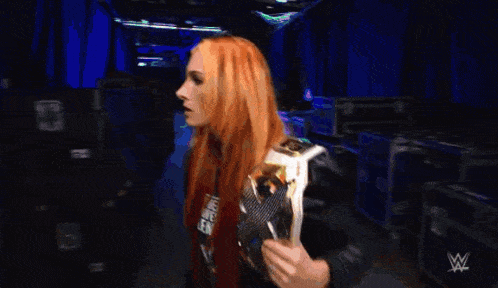 two women are standing next to each other and one of them has a wrestling logo on her jacket