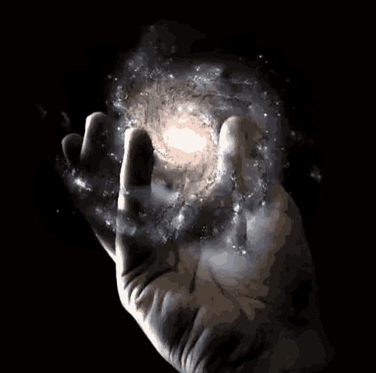 a hand holding a galaxy in it 's fingers