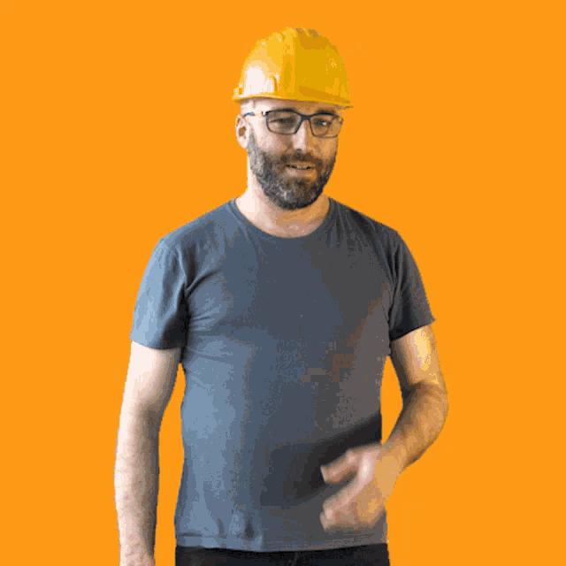 a man wearing a hard hat and glasses is smiling for the camera