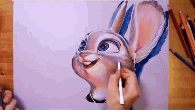 a person is drawing a bunny with a pencil on a piece of paper