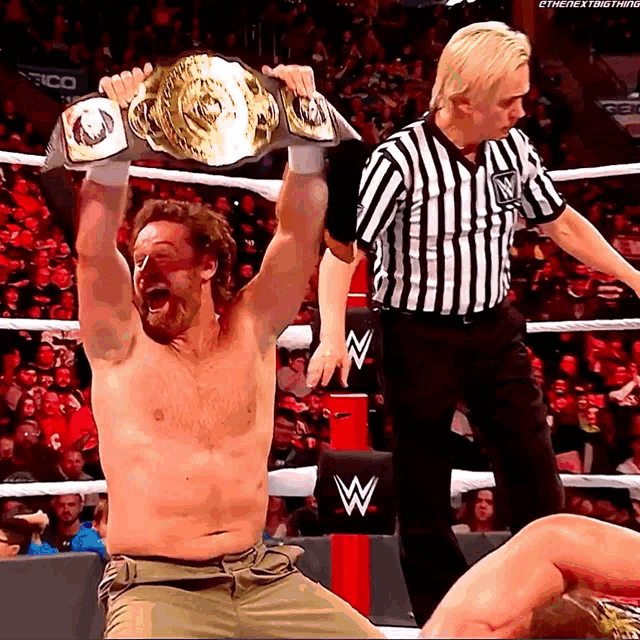 a shirtless wrestler is holding a wrestling championship belt