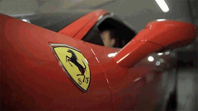 a close up of a red ferrari with a horse on it