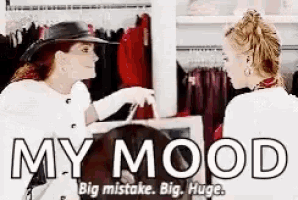 a woman is talking to another woman in a clothing store while holding a bag .