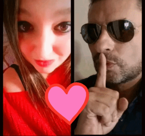 a man wearing sunglasses and a woman wearing a red sweater with a pink heart behind them