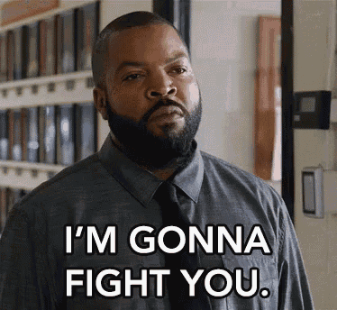 a man with a beard and tie is standing in a hallway and says `` i 'm gonna fight you '' .