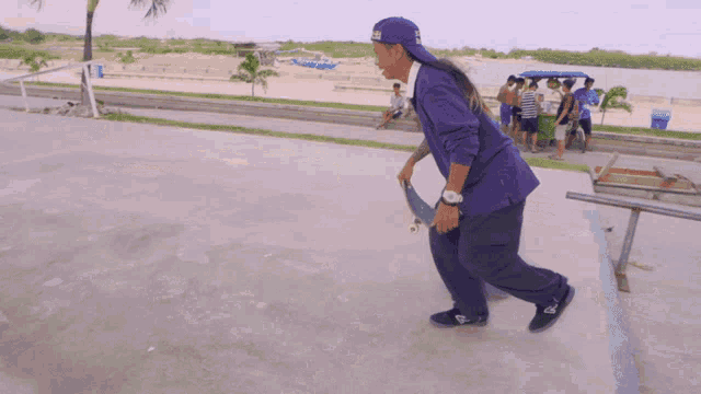 a person wearing a purple shirt and a blue hat with the word la on it