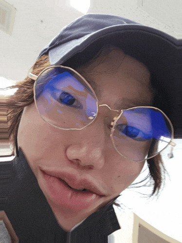 a person wearing glasses and a hat is making a face