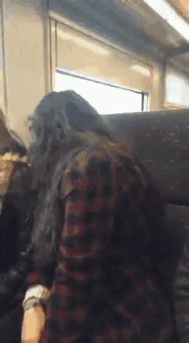 a woman in a plaid shirt sits next to another woman